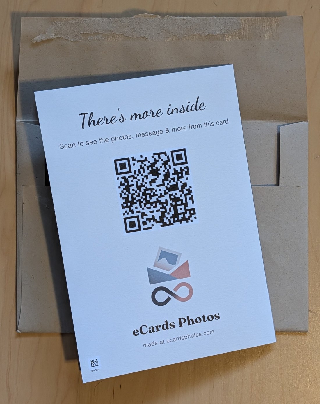 The back of the card, printed with There's more inside, Scan to see the photos, message and more from this card, above a QR code and the eCards Photos mark